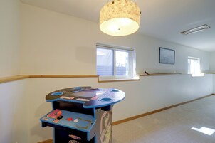 Una habitación con una mesa de juegos, un ventanal y una lámpara en el techo.