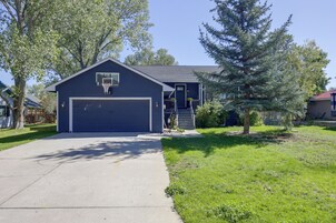 Ein zweistöckiges Haus mit Garage, Basketballkorb und gepflegtem Rasen.