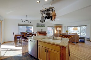 A spacious kitchen with granite countertops, wooden cabinets, and a hanging pot rack. - Private Sauna at Family-friendly Eagle Home W/deck (Eagle)
