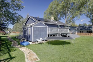 A residential property with a house, a fenced yard, a trampoline, and a patio area.
