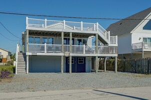 A two-story building with a balcony, a garage, and a sign that reads 'Salty Chateau.'