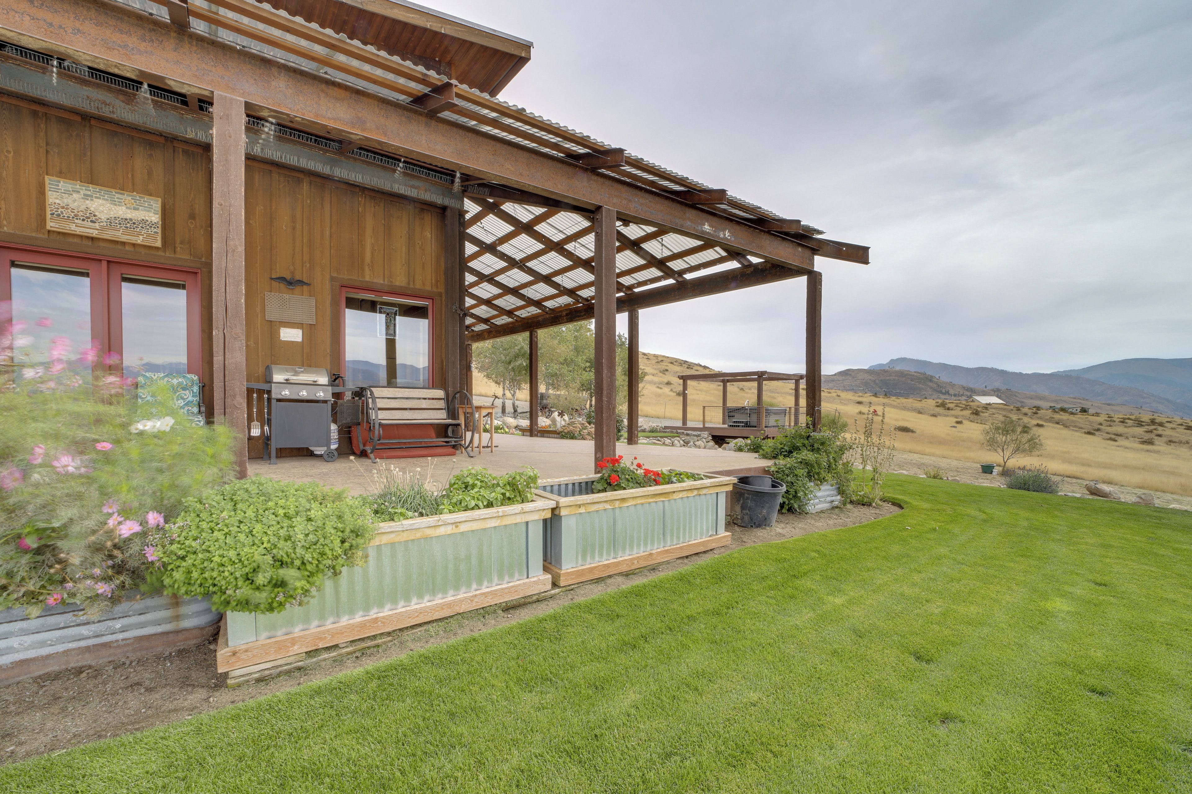 A rustic building with a covered patio, outdoor seating, and a view of the surrounding landscape.