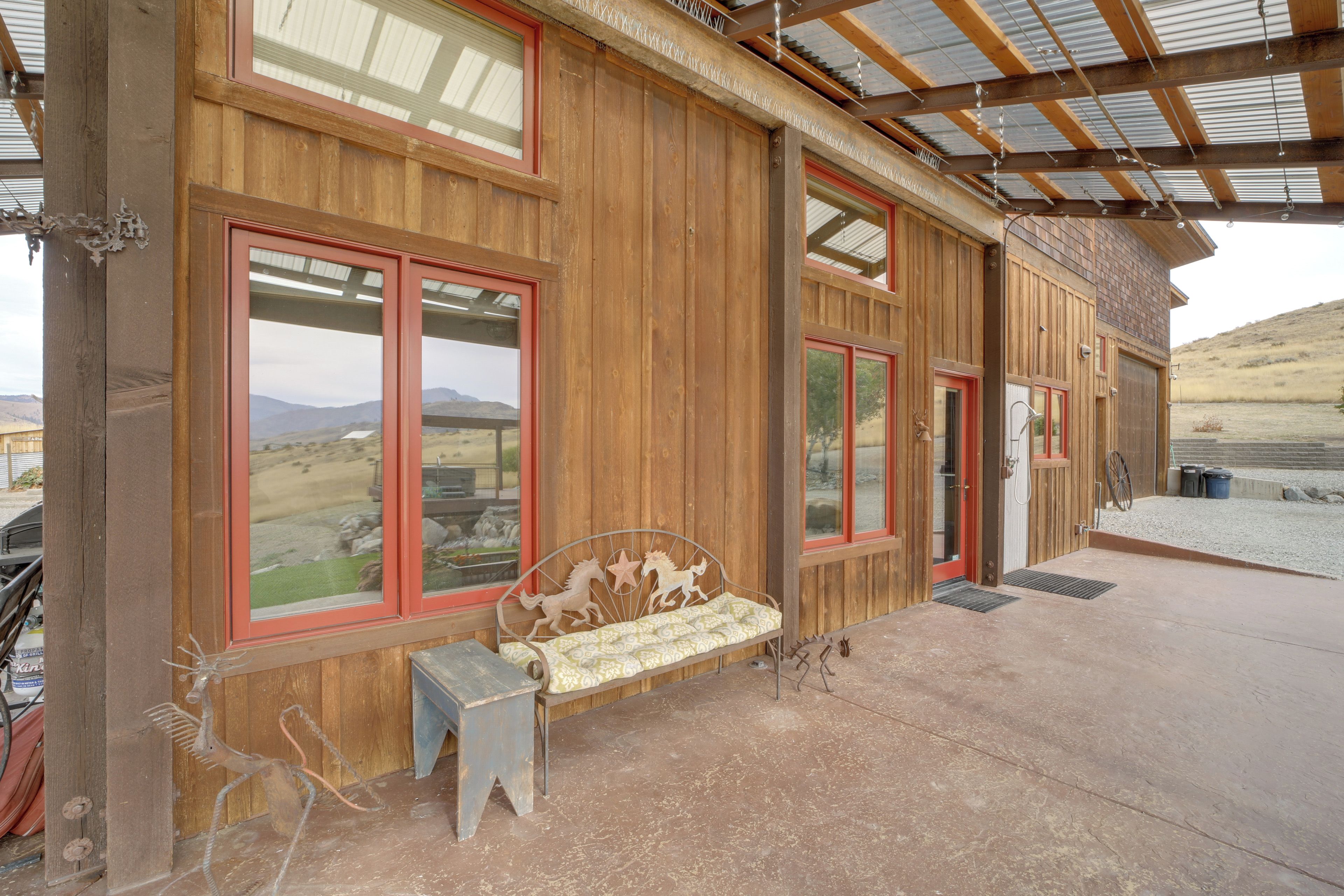 A wooden building with large windows and a covered patio area.