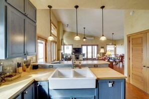 A kitchen with a central island, pendant lighting, and a view to the dining area.
