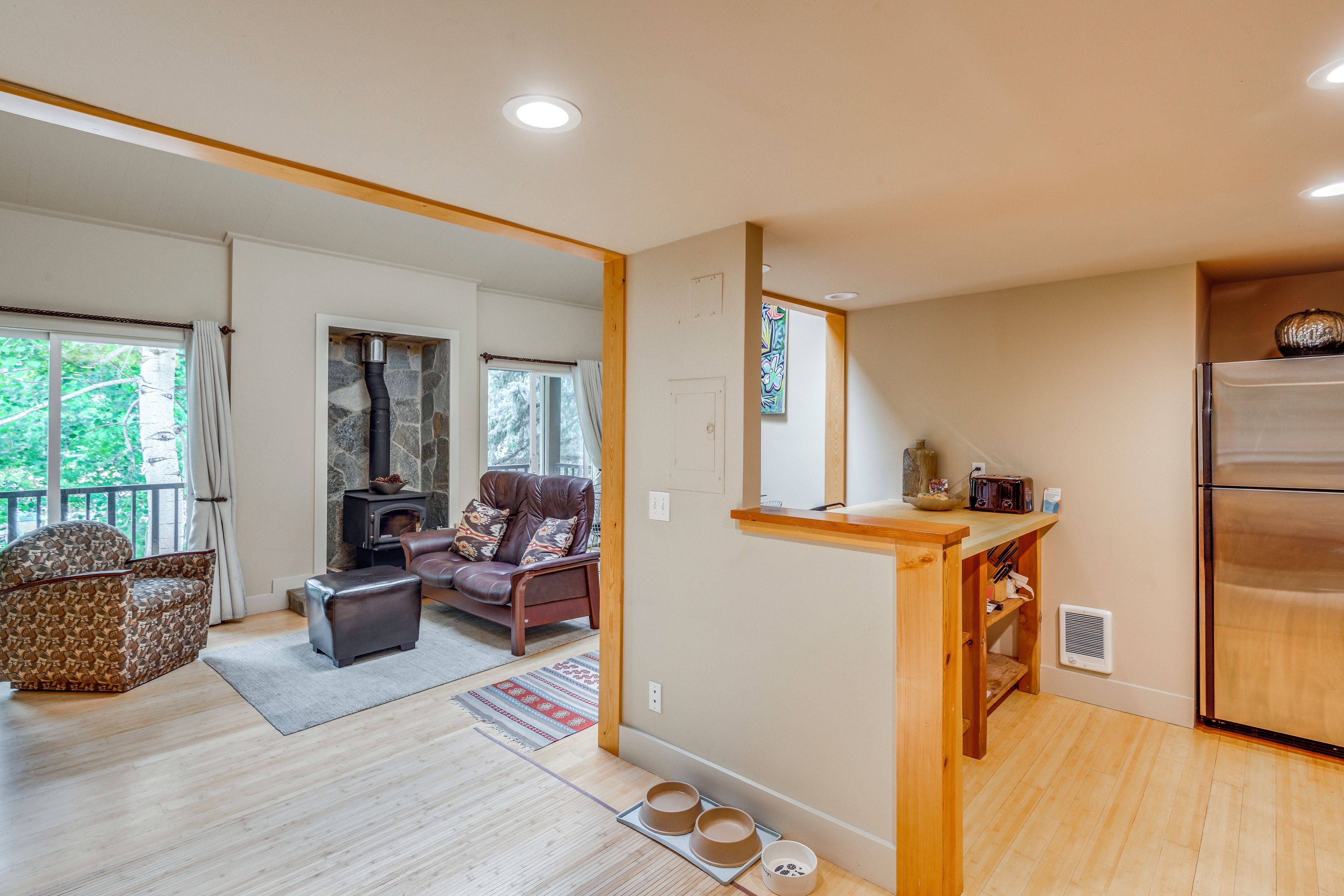 A spacious living area with a fireplace, seating, and a kitchen area with a refrigerator.