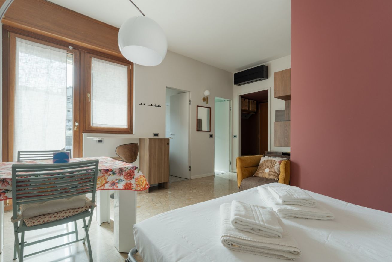 Een hotelkamer met een bed, een stoel, een tafel en een kledingkast.