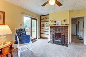 Ein gemütliches Wohnzimmer mit Kamin, einem Schaukelstuhl und einem Bücherregal mit religiösen Dekorationen.