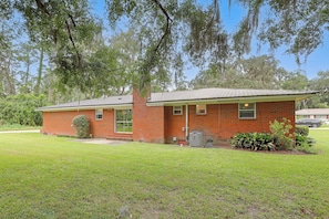 A single-story brick building with a flat roof, a front porch, and a small front yard.