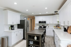 A modern kitchen with white cabinetry, stainless steel appliances, and a central island. - Outdoor Oasis w/ Hot Tub & Pool! Milford Gem (Milford)