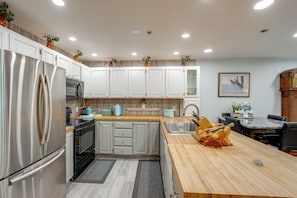A modern kitchen with white cabinets, stainless steel appliances, and a wooden countertop. - Walkable Dtwn Location! Extended Anchorage Stay (Anchorage)