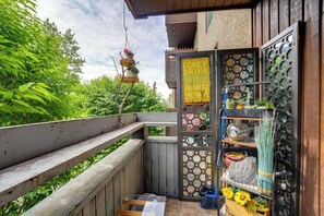 A wooden balcony with a hanging planter, a sign indicating a wine-only policy, and a shelf with various items. - Walkable Dtwn Location! Extended Anchorage Stay (Anchorage)