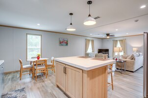A modern kitchen with wooden cabinets, a central island, and pendant lighting.