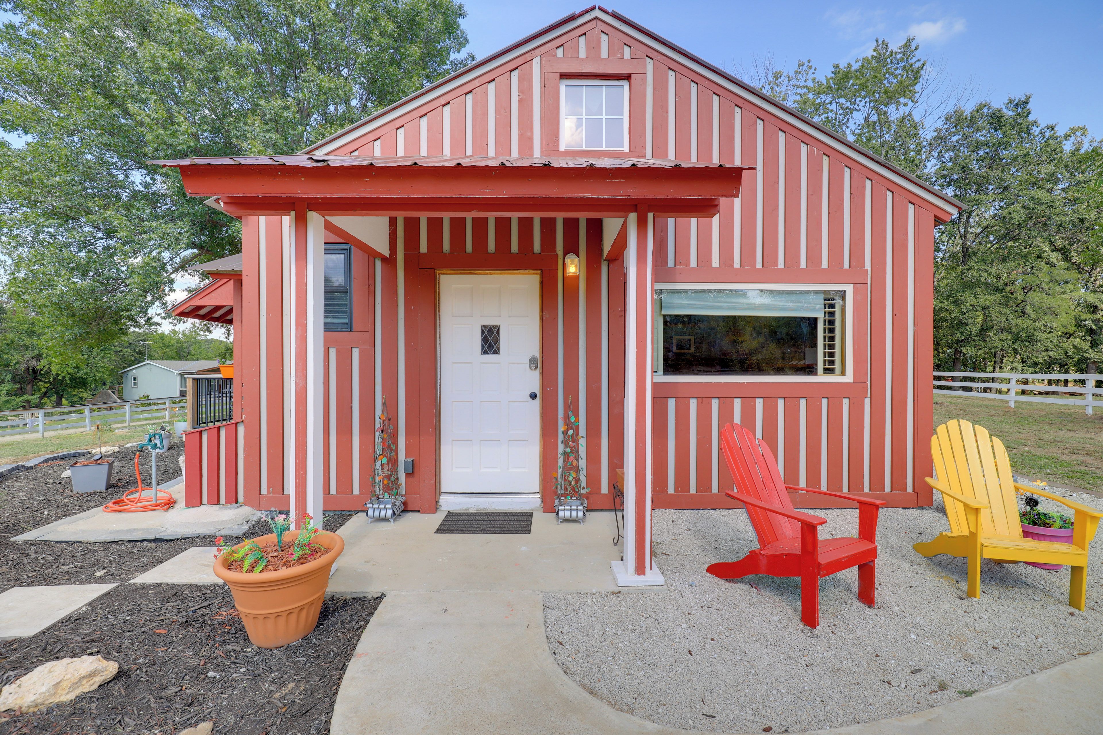 A red and white striped house with a front door, two windows, and a porch area.