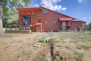 A red wooden house with a deck and a small garden area. - Harbour View - Lake Cabin w/ Game Room & Fire Pit (Odessa)