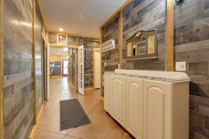 A hallway with wooden walls, a reception desk, and a door leading to another room.