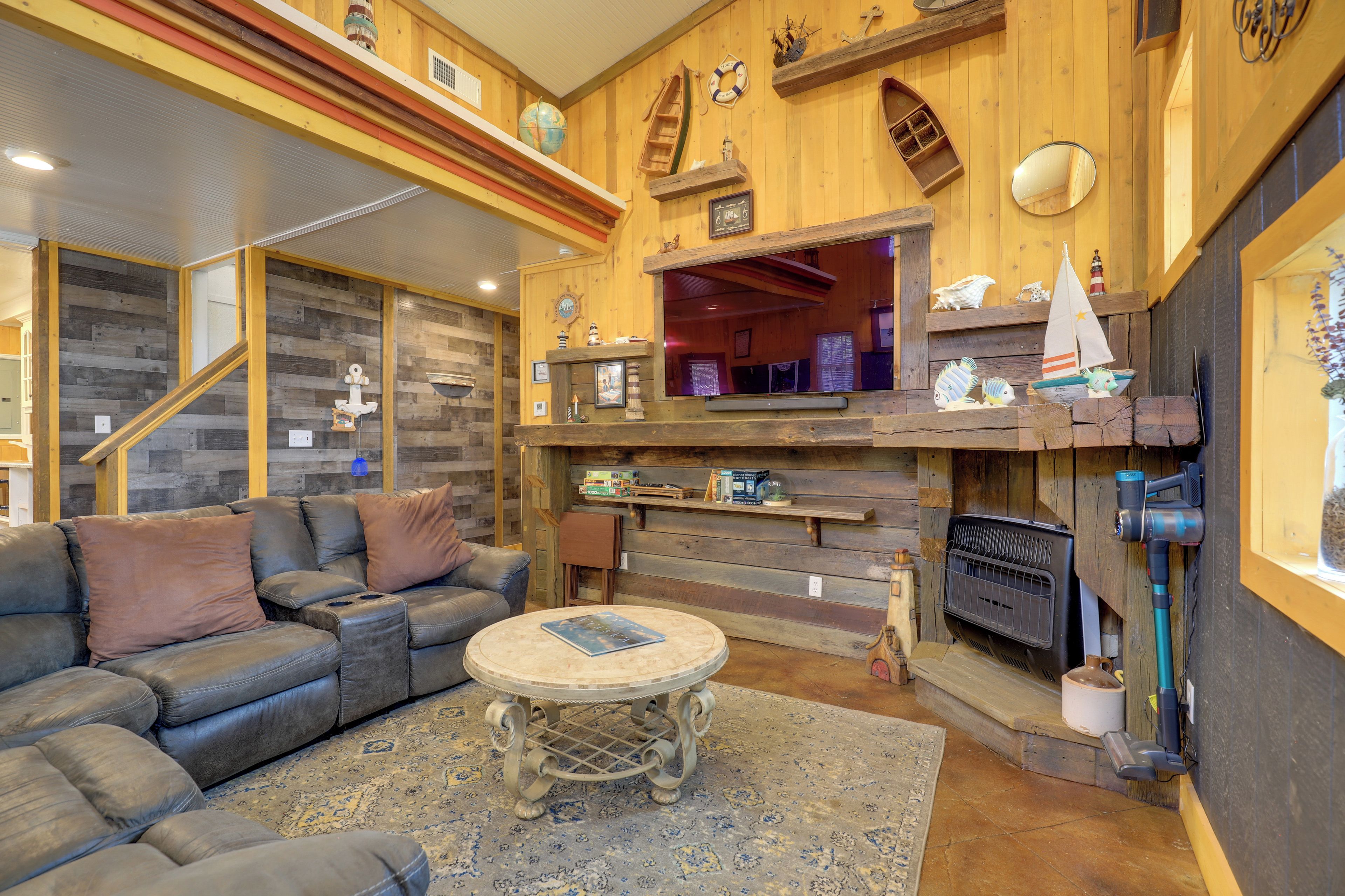 A cozy living room with a leather sofa, a round coffee table, and a fireplace.