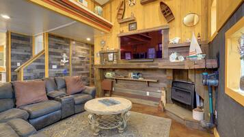 A cozy living room with a leather sofa, a round coffee table, and a fireplace.