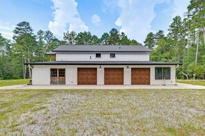 A two-story building with a garage and a covered porch.