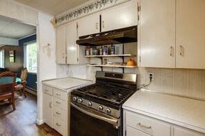 A kitchen with white cabinets, a stove, and a countertop.