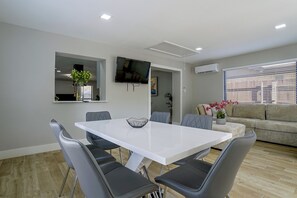 A modern dining area with a white table, grey chairs, and a decorative bowl. - Cozy Home Base Btwn Dallas & Fort Worth (Bedford)