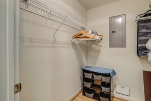A walk-in closet with a metal shelving unit, a wooden hanger rack, and a blue-covered storage unit with multiple compartments. - Private Yard & Patio! Hopewell Extended Stay (Hopewell)