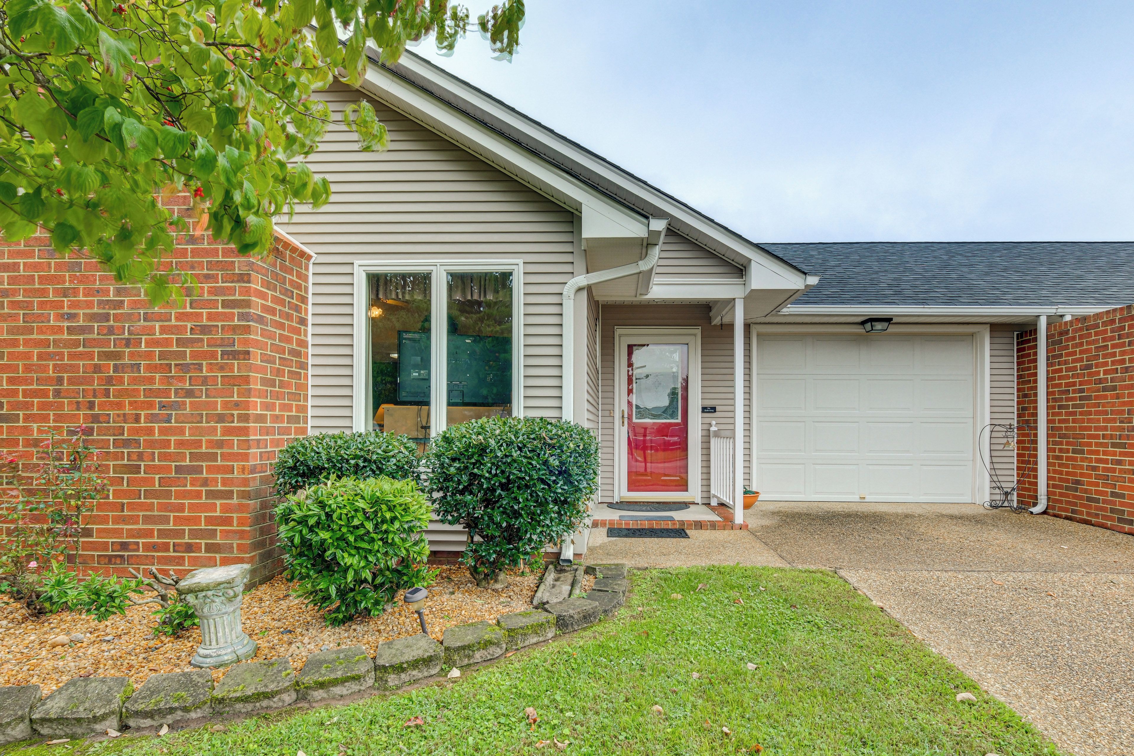 A residential house with a garage, a brick wall, and a well-maintained lawn.