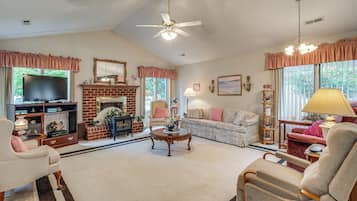 A living room with a fireplace, television, and comfortable seating.