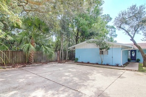 A residential property with a single-story house, a fenced backyard, and mature trees. - Bayfront Unit w/ Hot Tub & Dock Access! (Fort Walton Beach)