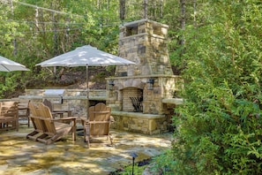 An outdoor patio with stone barbecue and seating. - Brevard Retreat w/ Hot Tub & Copper Soaking Tub (Brevard)