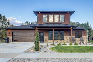 A modern two-story house with a garage, large windows, and a well-maintained front yard with a lawn and decorative plants. - Mtn Views & On-site Creek! Red Lodge Gem (Red Lodge)