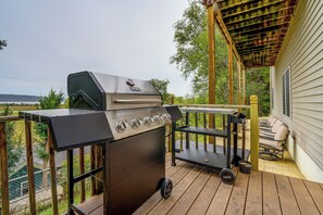 Ein Grill im Freien auf einer Holzterrasse mit Blick auf den Ozean.