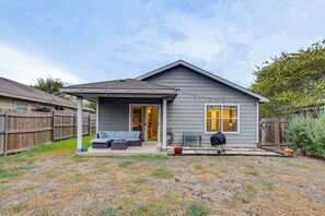 A residential house with a covered patio, a sliding glass door entrance, and a small outdoor seating area with a sofa and table. - Easy Airport Access! Austin Home w/ Patio (Austin)