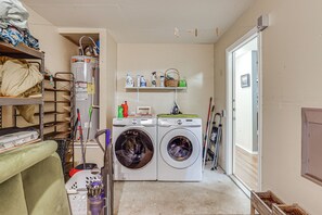 A laundry room with two washing machines, shelves with cleaning supplies, and a water heater. - Easy Airport Access! Austin Home w/ Patio (Austin)