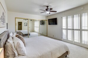 A bedroom with a bed, a ceiling fan, a TV, and a sliding door. - Sip, Soak & Stargaze: Palm Desert Retreat! (Palm Desert)