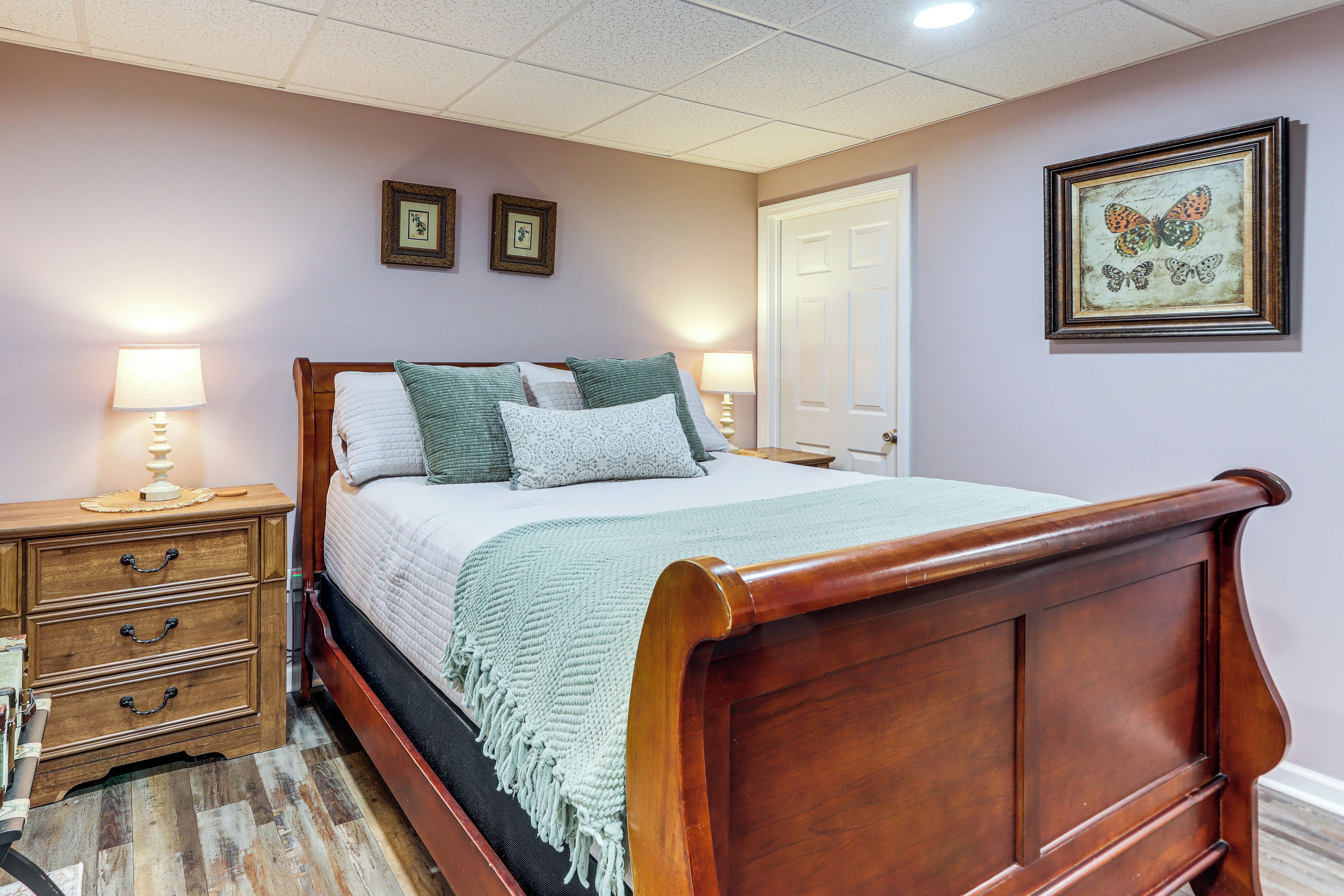 Un dormitorio con cama de madera, mesitas de noche y una puerta.