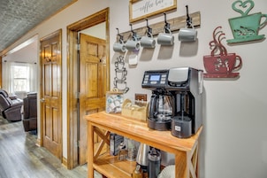 Estação de café com cafeteira, xícaras e moedor.