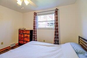 A bedroom with a bed, a dresser, a window with curtains, and a ceiling fan. - Yard & Patio Family Home Near Pittsburgh (West Mifflin)