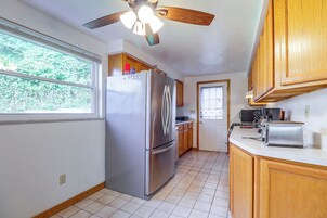 Una cocina compacta con refrigerador, estufa y ventana.
