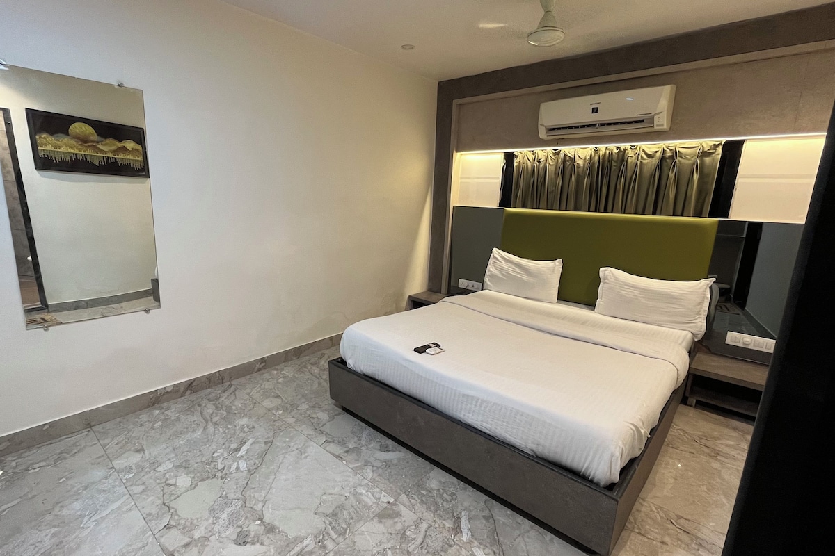 Une chambre d’hôtel avec un lit, un miroir, un appareil de climatisation et un sol en marbre.