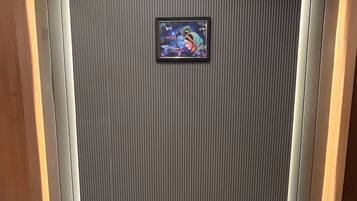 A room with a marble floor, a framed artwork on a textured wall, and wooden paneling.