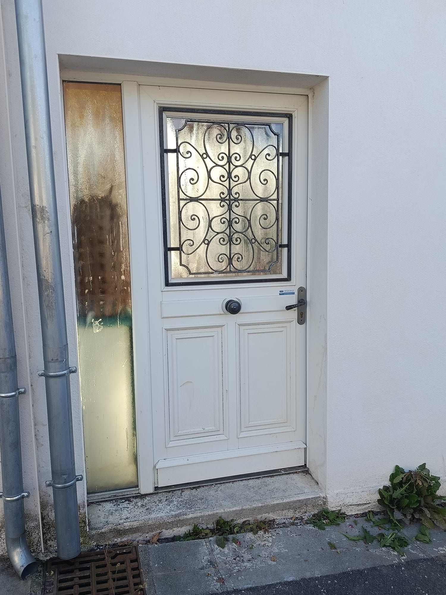 A white door with a decorative glass panel and a metal handle.