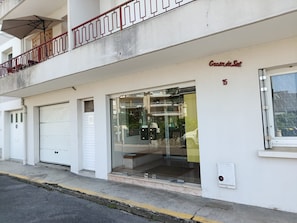 A building with a ground-floor entrance, a balcony with a railing, and a sign indicating the name 'Grande de Sol'. - All on foot • Private parking • 2 bedrooms (Le Pouliguen)