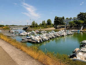A marina with boats docked, a bridge in the background, and a building with a flat roof. - All on foot • Private parking • 2 bedrooms (Le Pouliguen)