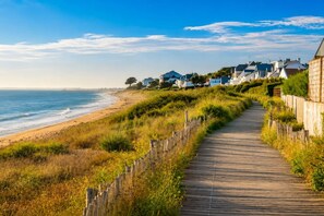 A wooden boardwalk along a beach with houses in the background. - Beach within walking distance • Master bedroom • 8 people (Pornichet)