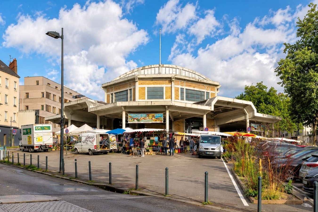 Un marché composé d’un bâtiment central et de stands disposés autour.