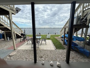 An outdoor patio with a view of the water, a grill, and seating. - Manasota Key Waterfront Condo Full Kitchen 1 Bed Boat Dock Beach Access Kayaks (Englewood)