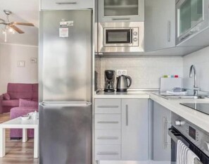 A modern kitchen with a stainless steel refrigerator, microwave, and oven. - Modern Seaside Apartment ~ Pool Near Torrox Beach (Urbanización Cerro Garbancito)