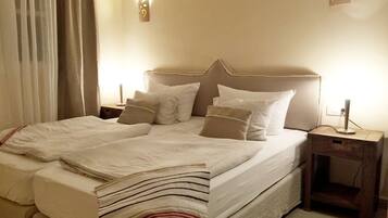A neatly made bed with a striped blanket, a headboard, and two bedside lamps.