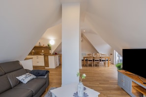 A modern loft apartment with a dining area, kitchen, and living space.