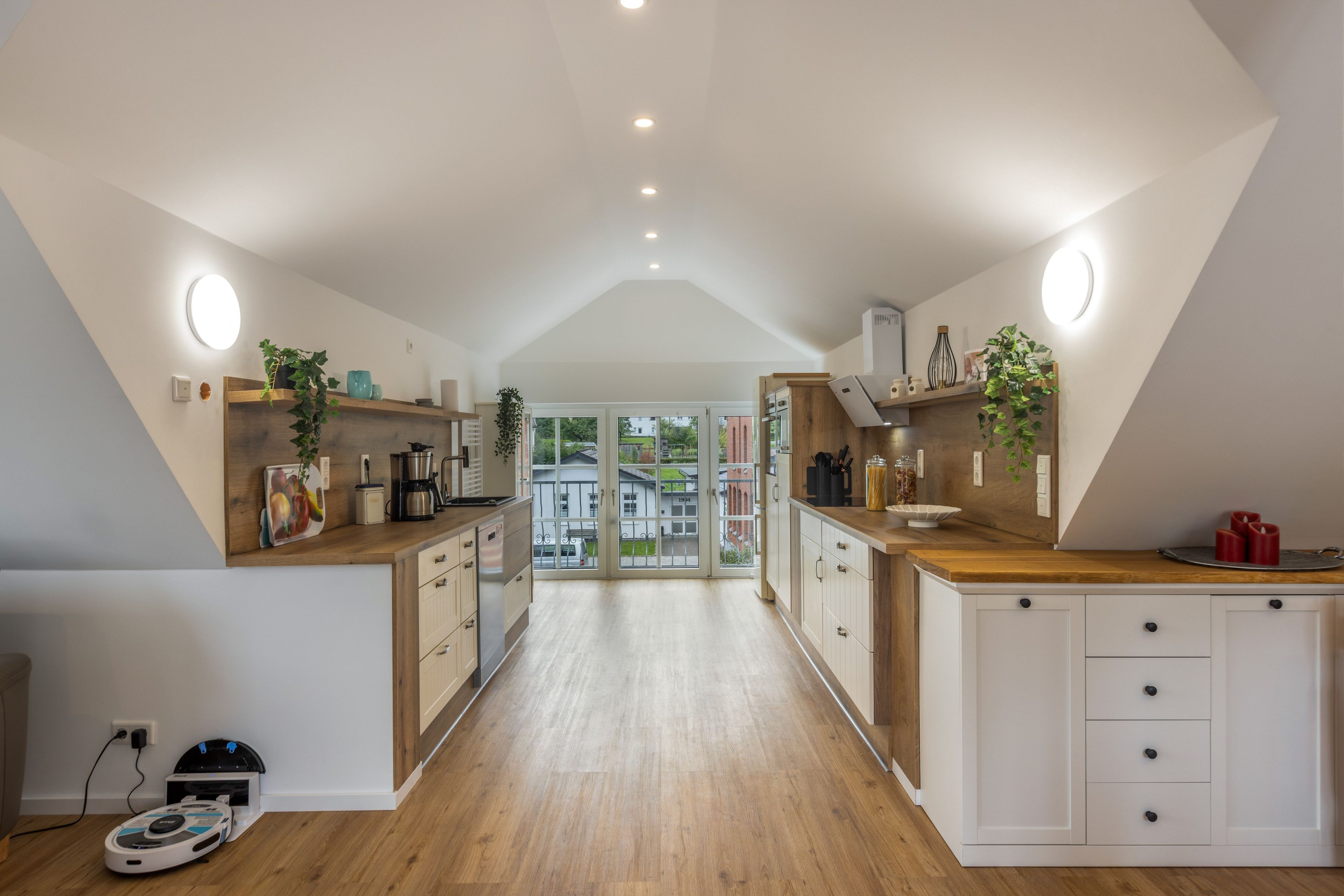 Een moderne keuken met houten kastjes, een centraal eiland en uitzicht naar buiten.